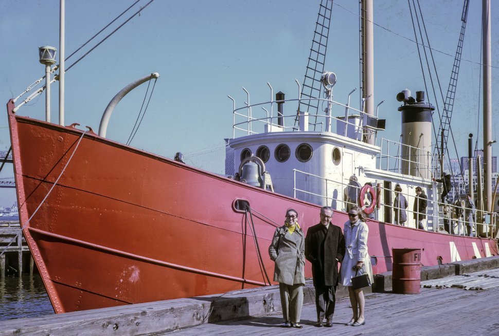 Free image of Three people posing on the dock in front of a small ship.