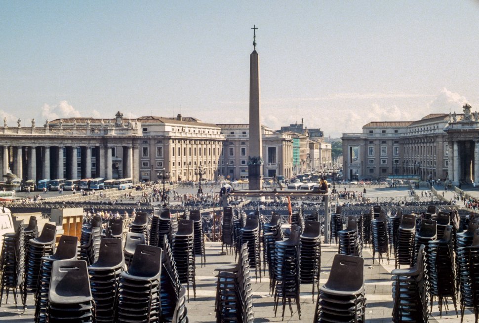 Free image of Piles of stacked chairs in a large courtyard with monument, Italy