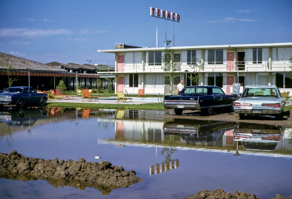 Free image of Hotel and Texaco gas station with reflection in puddle, USA