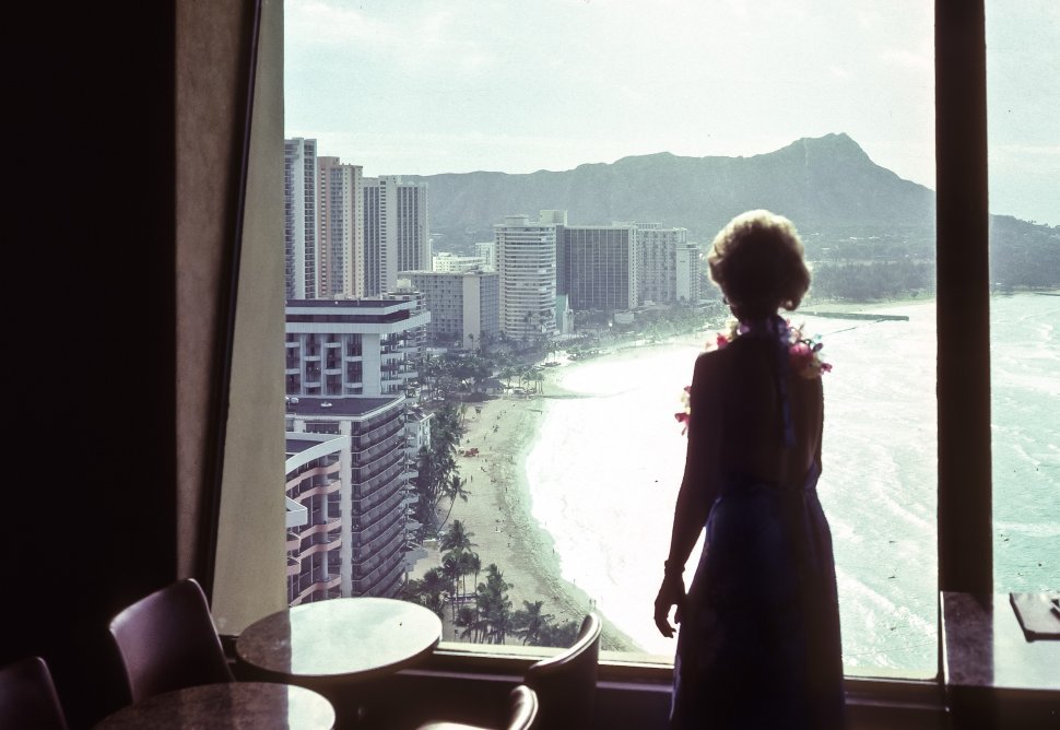 Free image of Woman looking out her hotel window at a spectacular view of the coast, Hawaii, USA