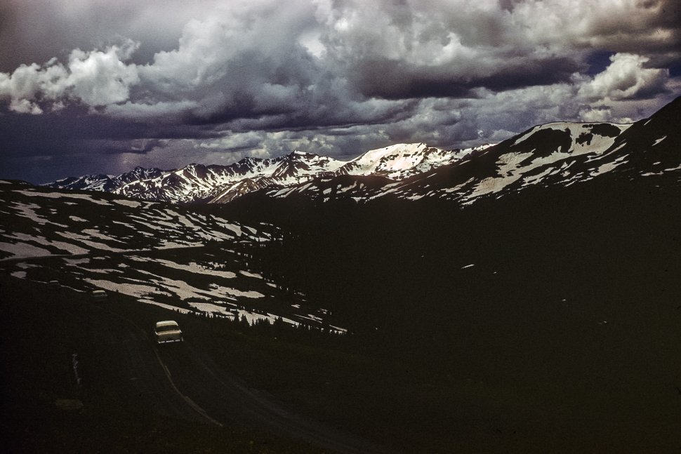 Free image of Threatening dark clouds above a snowy mauntain pass.