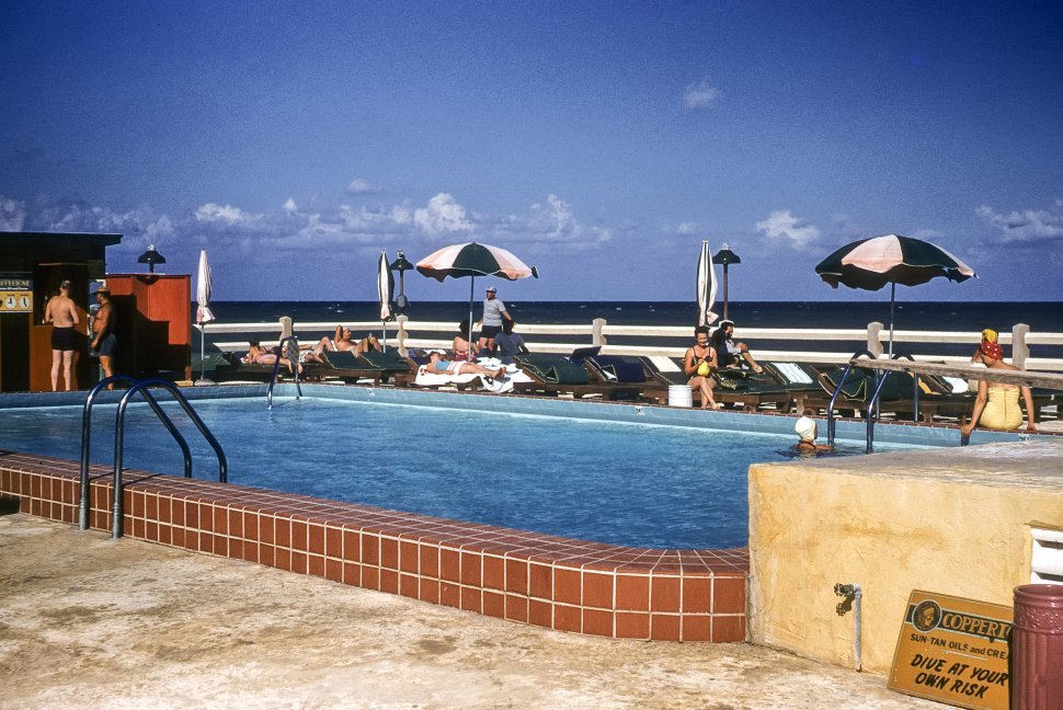 Free image of Tourists sunning themselves at an outdoor swimming pool next to the ocean, USA