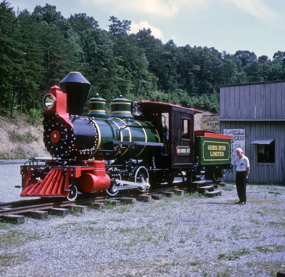 Free image of Man standing next to an antique train engine, USA