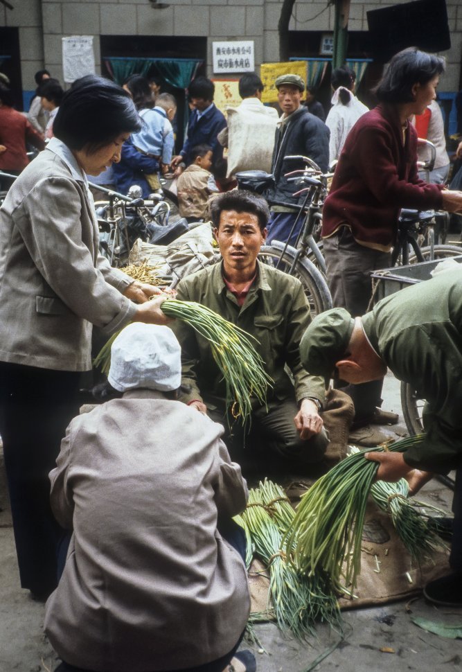 Free image of Vendors haggling with customers in a busy market, China