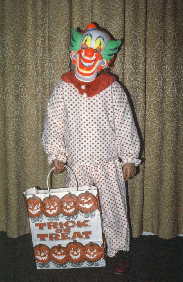 Free image of Halloween clown posing with trick-treat bag