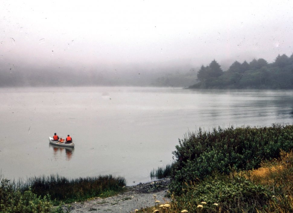 Free image of Three people wearing life saving jackets seen in boat in the river